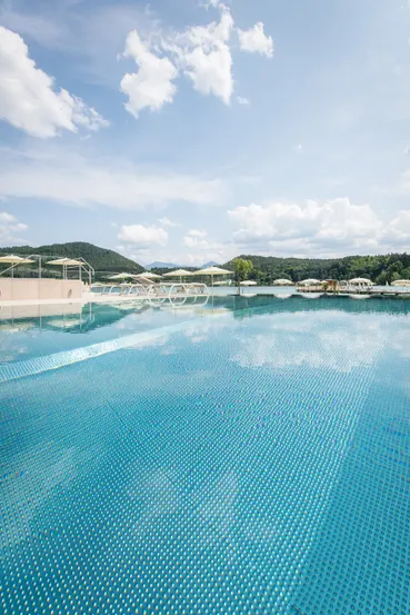 Infinity Pool und See Hotel Sonne Blick über Pool direkt zum See