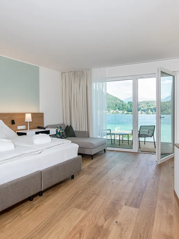 Doppelzimmer Morgentau Doppelbett vor türkiser Wand mit Blick auf Balkon